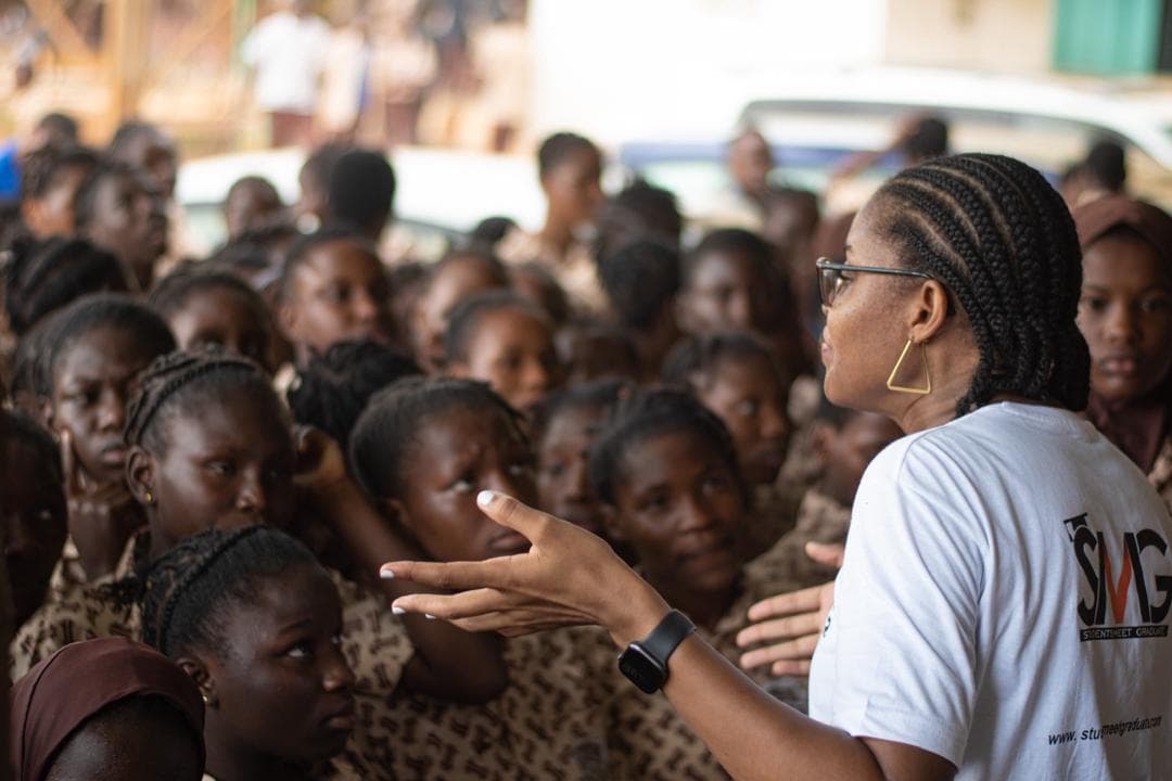 A Student Meets Graduate facilitator speaking to an assembly of students