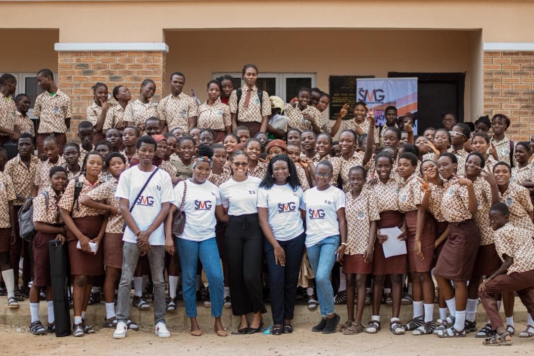 Students and Student Meets Graduate volunteers gathered outside a school
